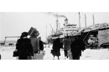 Un gruppo di persone di spalle cammina verso una grande nave ormeggiata. Le persone portano con sé valigie e bagagli, e la scena è ambientata in un ambiente invernale, con neve a terra. La nave, visibile sulla destra, emette fumo dal camino e appare pronta a partire.