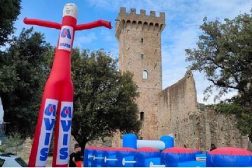 La locandina celebra il 55° anniversario di AVIS Castelnuovo Magra. Lo sfondo generale è di colore rosso scuro con il testo in bianco o giallo chiaro per un buon contrasto con l'immagine stilizzata di un cuore con una sacca per la raccolta del sangue e le gocce di sangue, simbolo della donazione. Quindi, si staglia l'illustrazione di un centro storico fortificato, che rappresenta il Castello dei Vescovi di Luni nel centro storico di Castelnuovo Magra. 
Sotto la voce "PROGRAMMA"sono elencati i diversi appuntamenti che si susseguono dalle ore 9 alle 12:30. Inoltre, vengono date altre informazioni: la data, il luogo principale, il punto di ritrovo, l’orario di accreditamento. Infine i contatti e i riferimenti sui social (sito, email, instagram).
