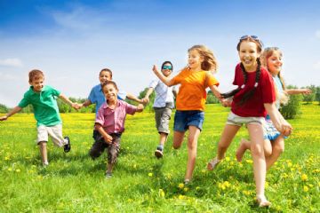 prato verde con 7 bambini che corrono felici.